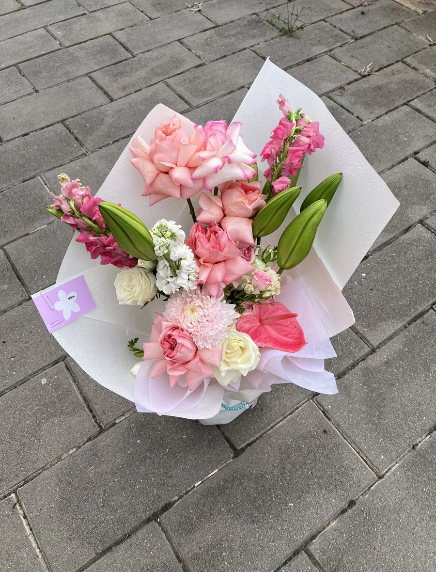 A close overhead view of a Chirri Floral bouquet with pink flowers and lilies.