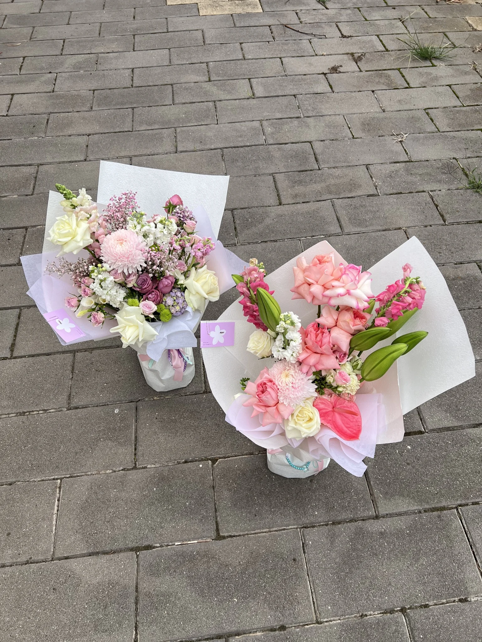 Two handcrafted Chirri Floral bouquets arranged on stone pavers.